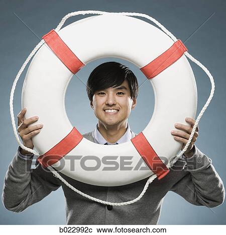man looking through the hole of a life preserver View Large Photo Image Stock Image - man looking through the hole of a life preserver. Fotosearch