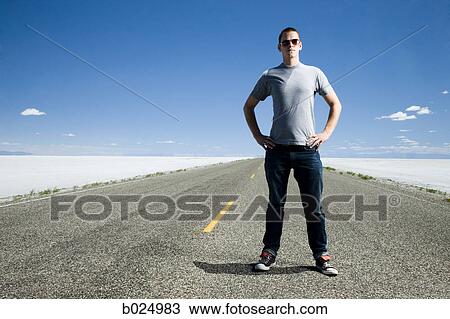 Stock Image - man on a road in the middle of nowhere. Fotosearch