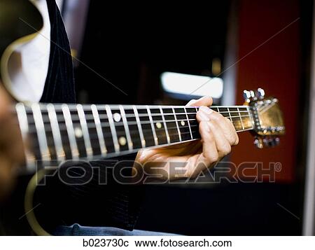 Stock Image - man playing a guitar. Fotosearch