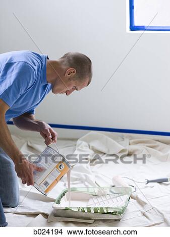 man pouring paint into a roller tray View Large Photo Image Picture - man pouring paint into a roller tray. Fotosearch
