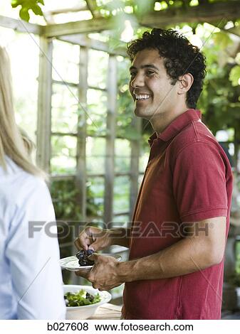 man serving himself food at an outdoor meal View Large Photo Image Stock Photo - man serving himself food at an outdoor meal. Fotosearch
