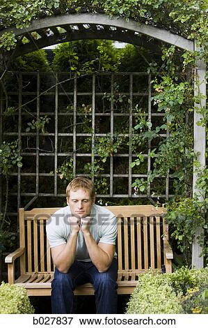man sitting on a bench with hands on chin View Large Photo Image Stock Photo - man sitting on a bench with hands on chin. Fotosearch