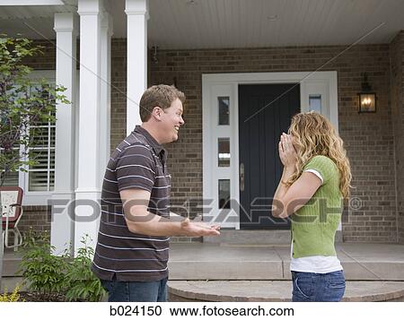man surprising wife in front of house View Large Photo Image Stock Image - man surprising wife in front of house. Fotosearch