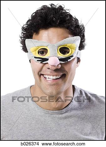 Picture - man wearing a kitty cat mask. Fotosearch