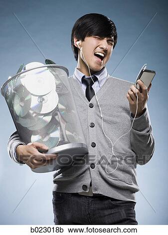 man with a trash can full of cd's and holding an iPod View Large Photo Image Stock Image - man with a trash can full of cd's and holding an iPod. Fotosearch