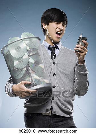 man with a trash can full of cd's and holding an iPod View Large Photo Image Stock Photo - man with a trash can full of cd's and holding an iPod. Fotosearch
