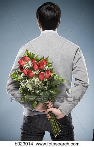 man with flowers behind his back View Large Photo Image Picture - man with flowers behind his back. Fotosearch