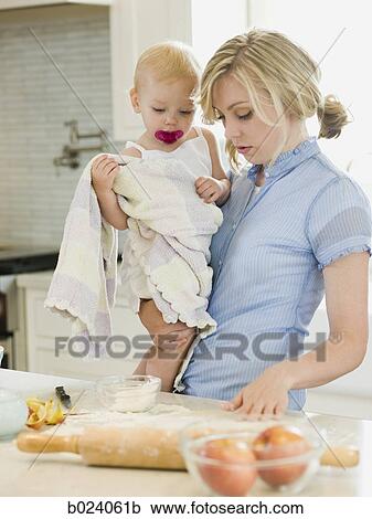 Stock Image - mother and baby girl cooking in the kitchen. Fotosearch