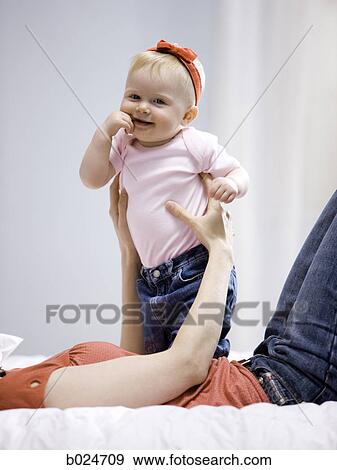 mother and baby girl lying on a bed View Large Photo Image Stock Photo - mother and baby girl lying on a bed. Fotosearch