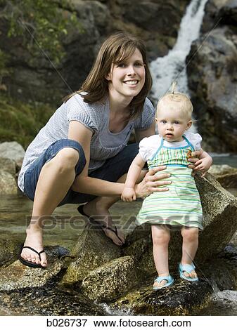 mother and baby in front of a waterfall View Large Photo Image Stock Photo - mother and baby in front of a waterfall. Fotosearch