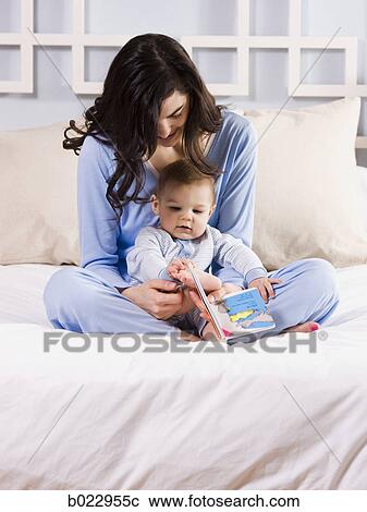Stock Image - mother and baby on a bed. Fotosearch
