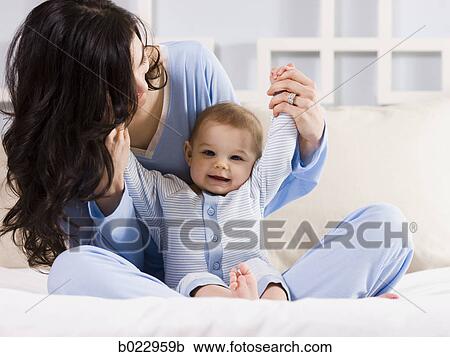 Stock Image - mother and baby on a bed. Fotosearch