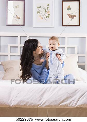 mother and baby on a bed View Large Photo Image Stock Image - mother and baby on a bed. Fotosearch