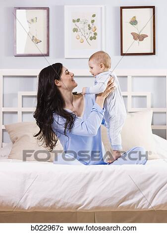 mother and baby on a bed View Large Photo Image Stock Image - mother and baby on a bed. Fotosearch