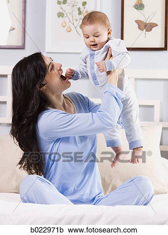mother and baby on a bed View Large Photo Image Stock Image - mother and baby on a bed. Fotosearch