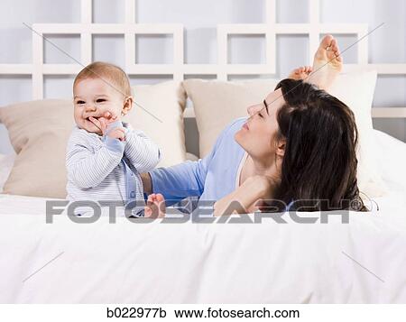 mother and baby on a bed View Large Photo Image Stock Image - mother and baby on a bed. Fotosearch