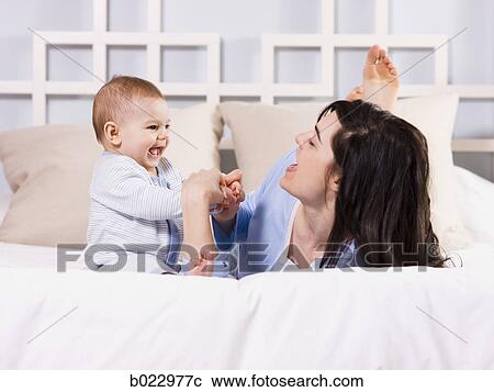 mother and baby on a bed View Large Photo Image Stock Image - mother and baby on a bed. Fotosearch