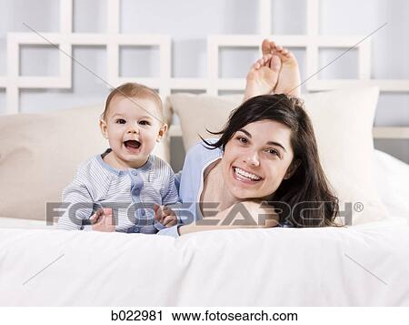 mother and baby on a bed View Large Photo Image Stock Image - mother and baby on a bed. Fotosearch