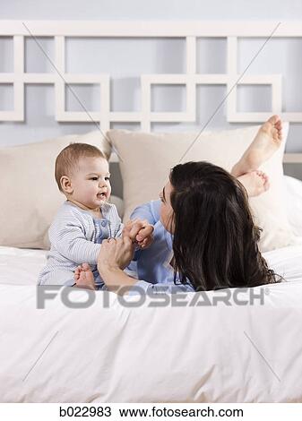 mother and baby on a bed View Large Photo Image Stock Image - mother and baby on a bed. Fotosearch