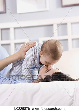 Stock Image - mother and baby on a bed. Fotosearch