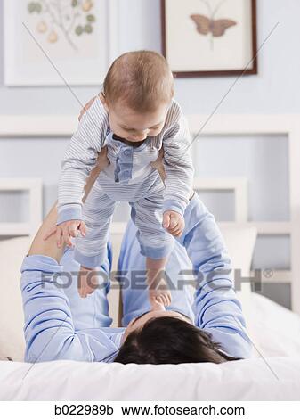 Stock Image - mother and baby on a bed. Fotosearch