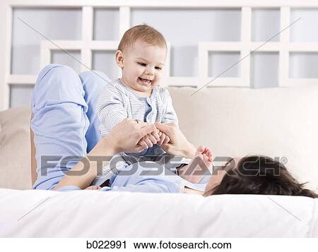 mother and baby on a bed View Large Photo Image Stock Image - mother and baby on a bed. Fotosearch