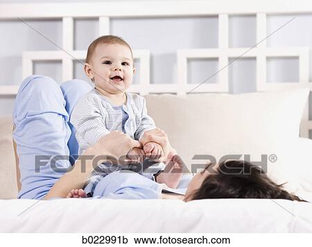 mother and baby on a bed View Large Photo Image Stock Image - mother and baby on a bed. Fotosearch