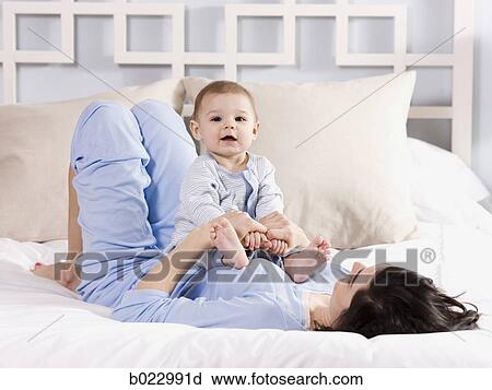 mother and baby on a bed View Large Photo Image Stock Image - mother and baby on a bed. Fotosearch