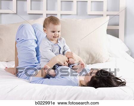 Stock Image - mother and baby on a bed. Fotosearch