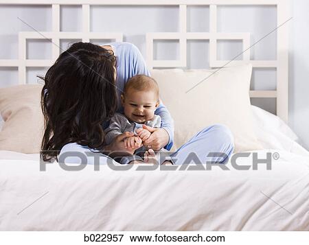 mother and baby on a bed View Large Photo Image Stock Photo - mother and baby on a bed. Fotosearch
