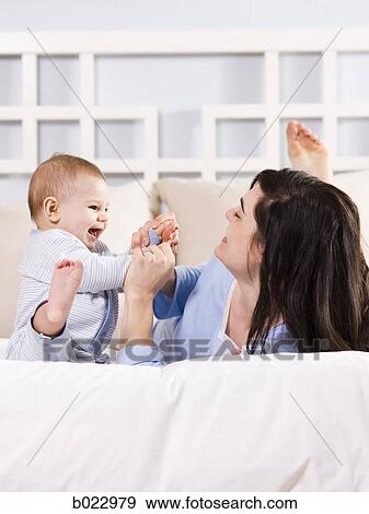 mother and baby on a bed View Large Photo Image Stock Photo - mother and baby on a bed. Fotosearch