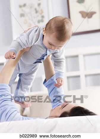 Stock Photo - mother and baby on a bed. Fotosearch