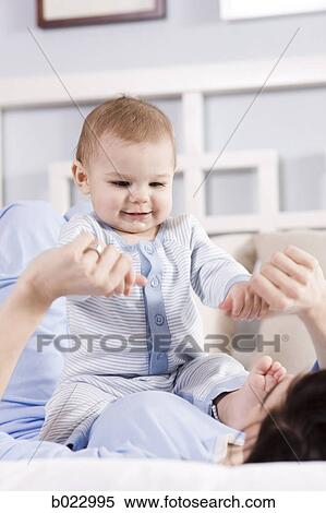mother and baby on a bed View Large Photo Image Stock Photography - mother and baby on a bed. Fotosearch
