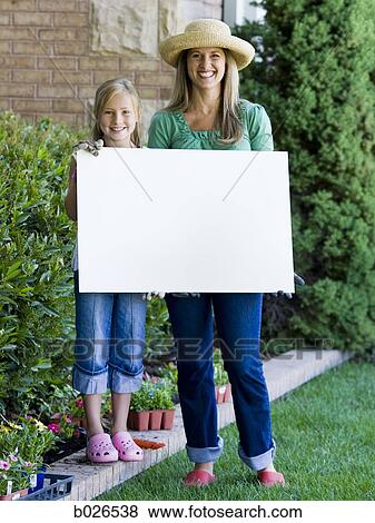 Stock Photo - mother and daughter holding a blank sign. Fotosearch