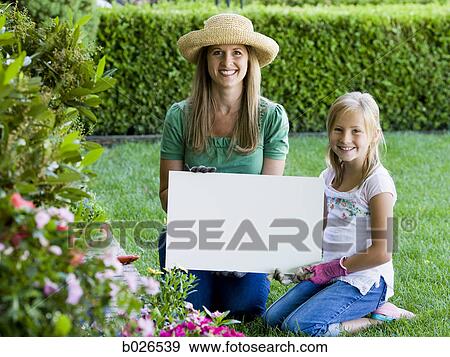 Stock Photo - mother and daughter holding a blank sign. Fotosearch