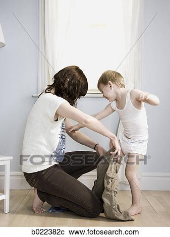 mother dressing her son View Large Photo Image Stock Image - mother dressing her son. Fotosearch