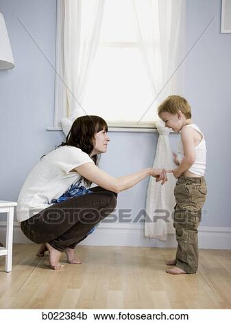 mother dressing her son View Large Photo Image Stock Image - mother dressing her son. Fotosearch