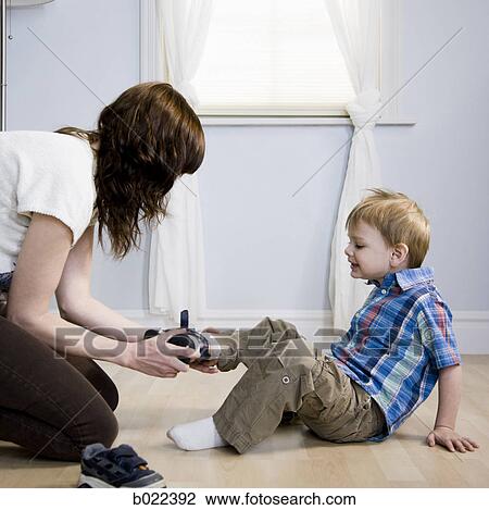 mother dressing her son View Large Photo Image Stock Image - mother dressing her son. Fotosearch