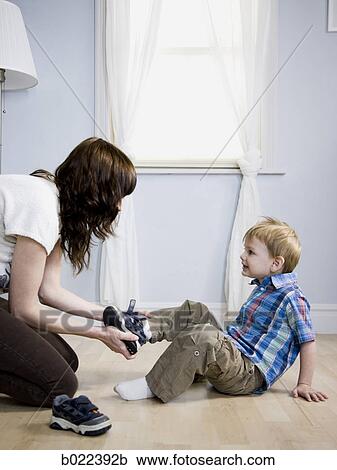 mother dressing her son View Large Photo Image Stock Image - mother dressing her son. Fotosearch