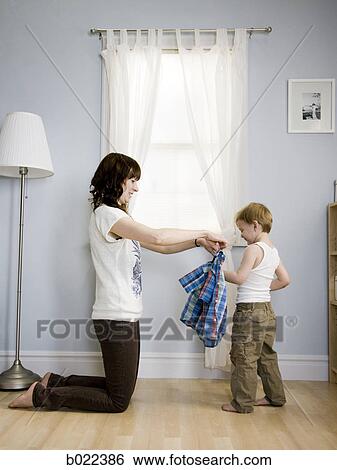 mother dressing her son View Large Photo Image Stock Photograph - mother dressing her son. Fotosearch