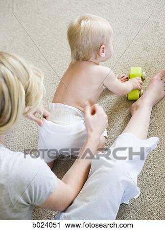 mother putting clothes on baby girl View Large Photo Image Stock Image - mother putting clothes on baby girl. Fotosearch