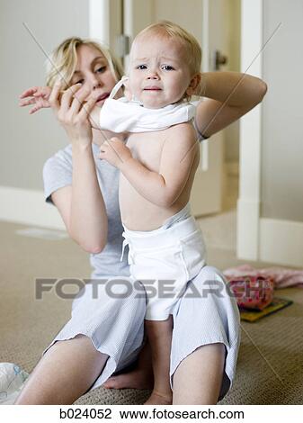 mother putting clothes on baby girl View Large Photo Image Stock Image - mother putting clothes on baby girl. Fotosearch