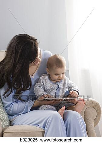 mother reading a book to her baby View Large Photo Image Stock Photography - mother reading a book to her baby. Fotosearch