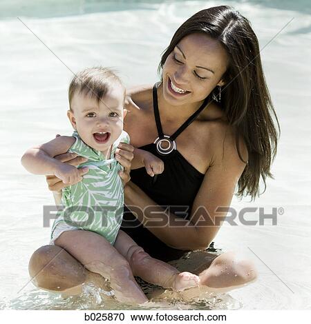 Stock Image - mother swimming with her baby girl. Fotosearch