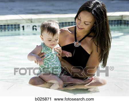 Stock Image - mother swimming with her baby girl. Fotosearch