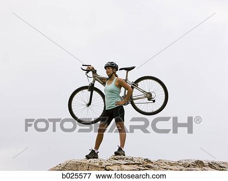 Stock Photo - mountain biker on a rocky ridge. Fotosearch