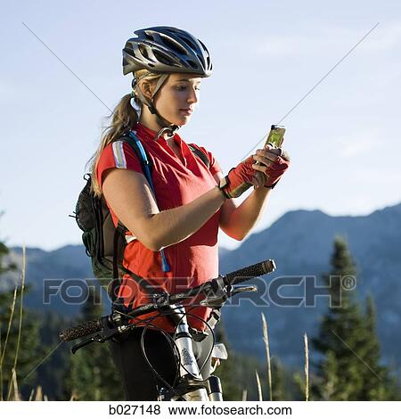 mountain biker stopping to use her cell phone in the middle of the wilderness View Large Photo Image Stock Photo - mountain biker stopping to use her cell phone in the middle of the wilderness. Fotosearch