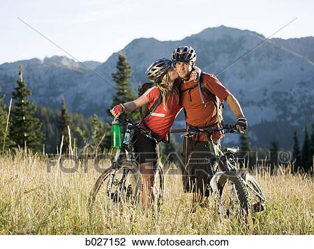 Stock Image - mountain bikers kissing. Fotosearch
