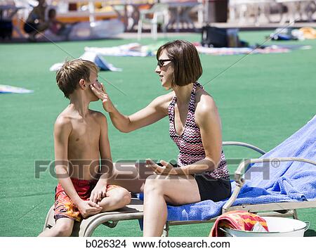 parent applying sunscreen to chld at water park View Large Photo Image Picture - parent applying sunscreen to chld at water park. Fotosearch