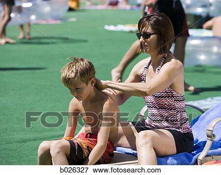 parent applying sunscreen to chld at water park View Large Photo Image Stock Photo - parent applying sunscreen to chld at water park. Fotosearch